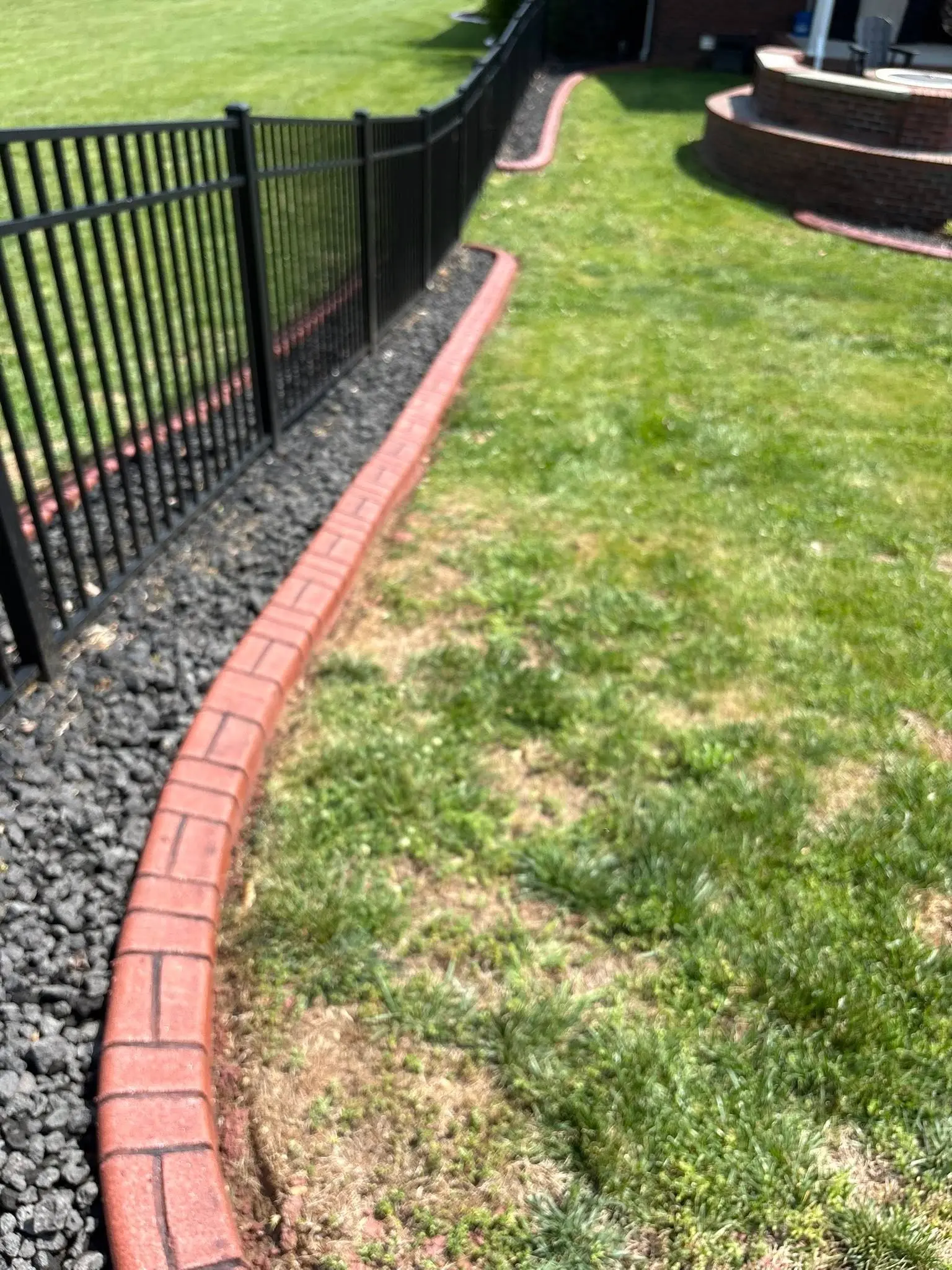 Stamped concrete curbing wrapping around a residential flower bed