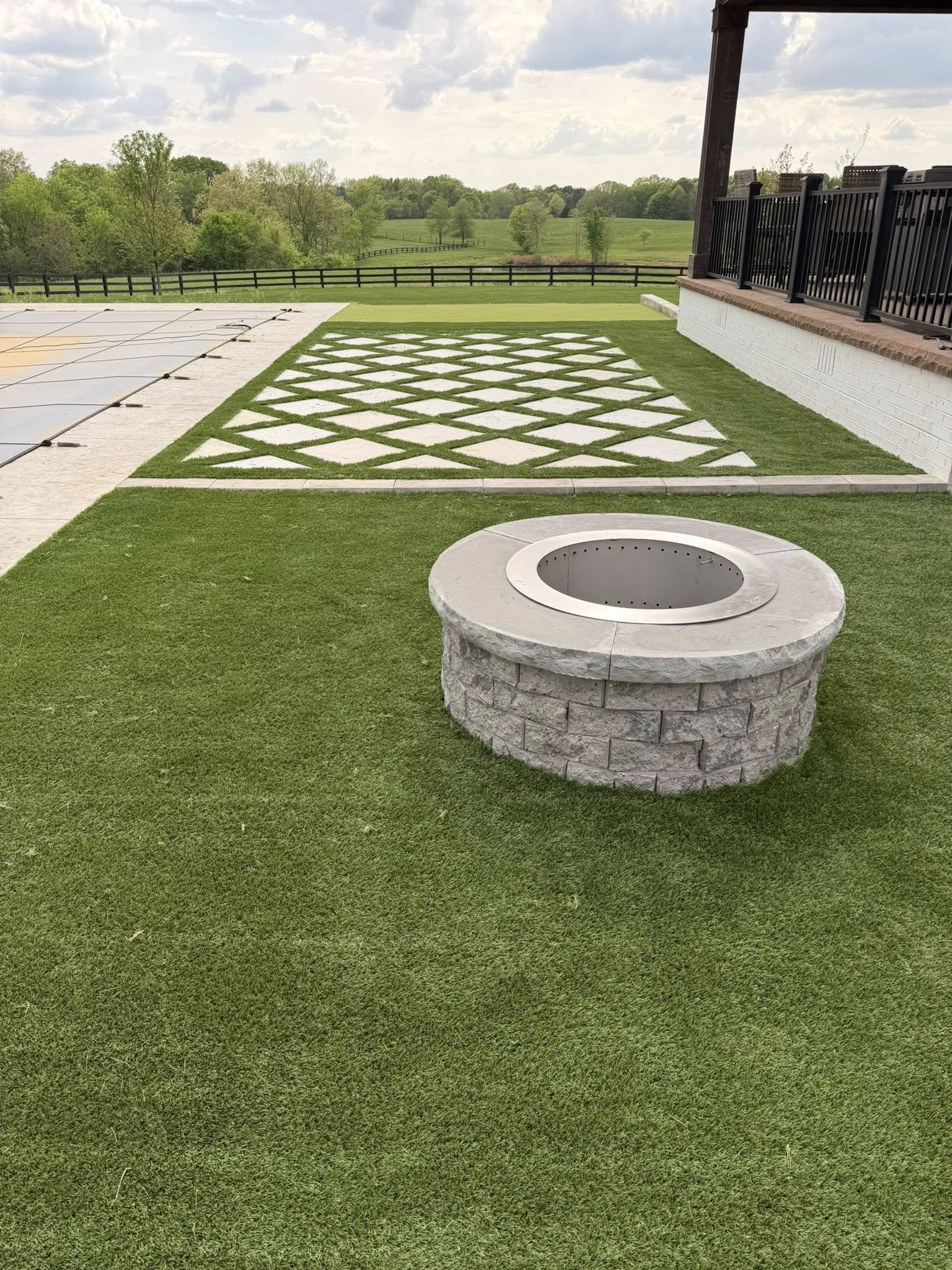 Backyard fire pit and stone patio at dusk — a recent installation by The Muscle